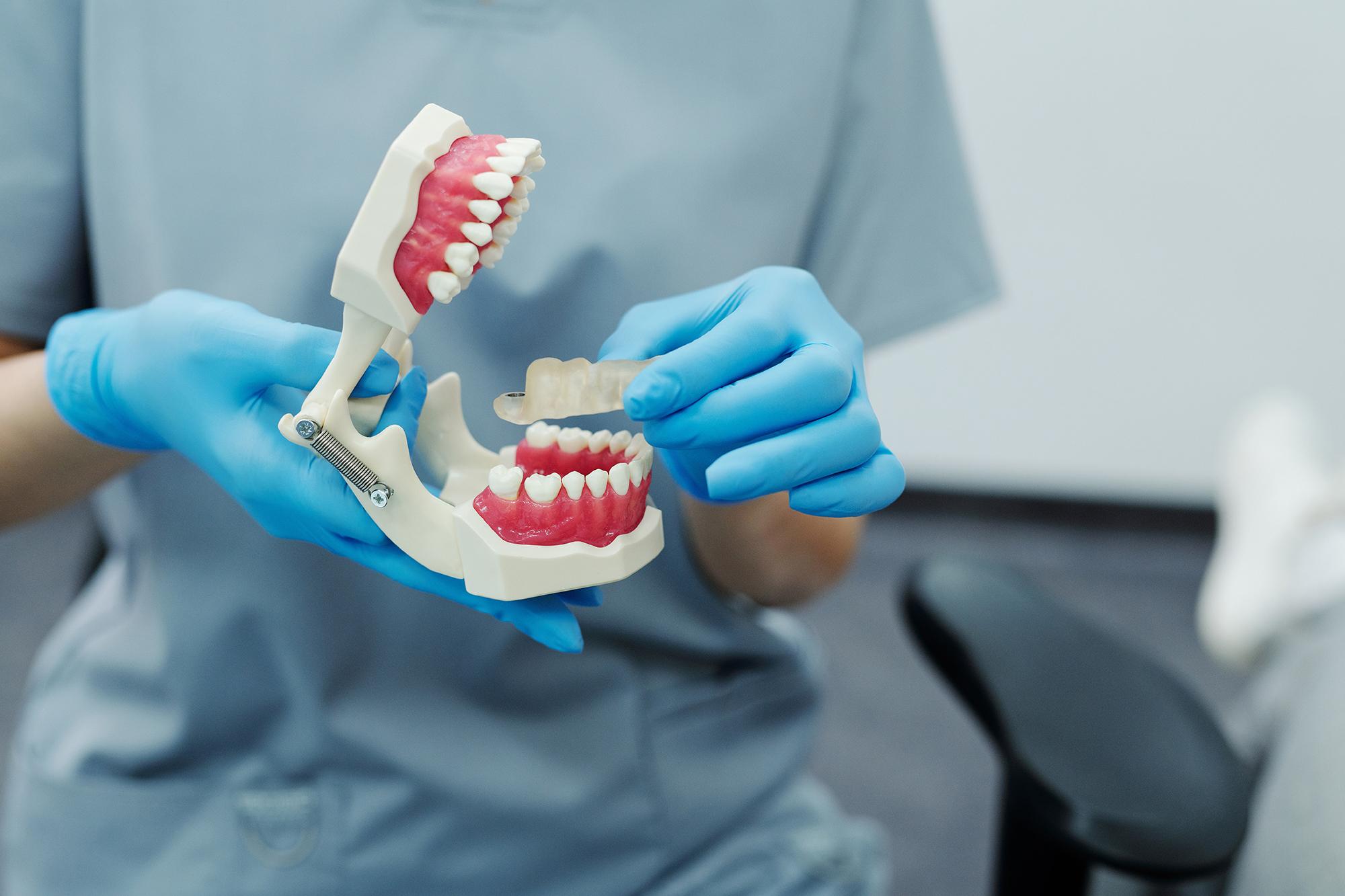 A dentist holding a pair of dentures